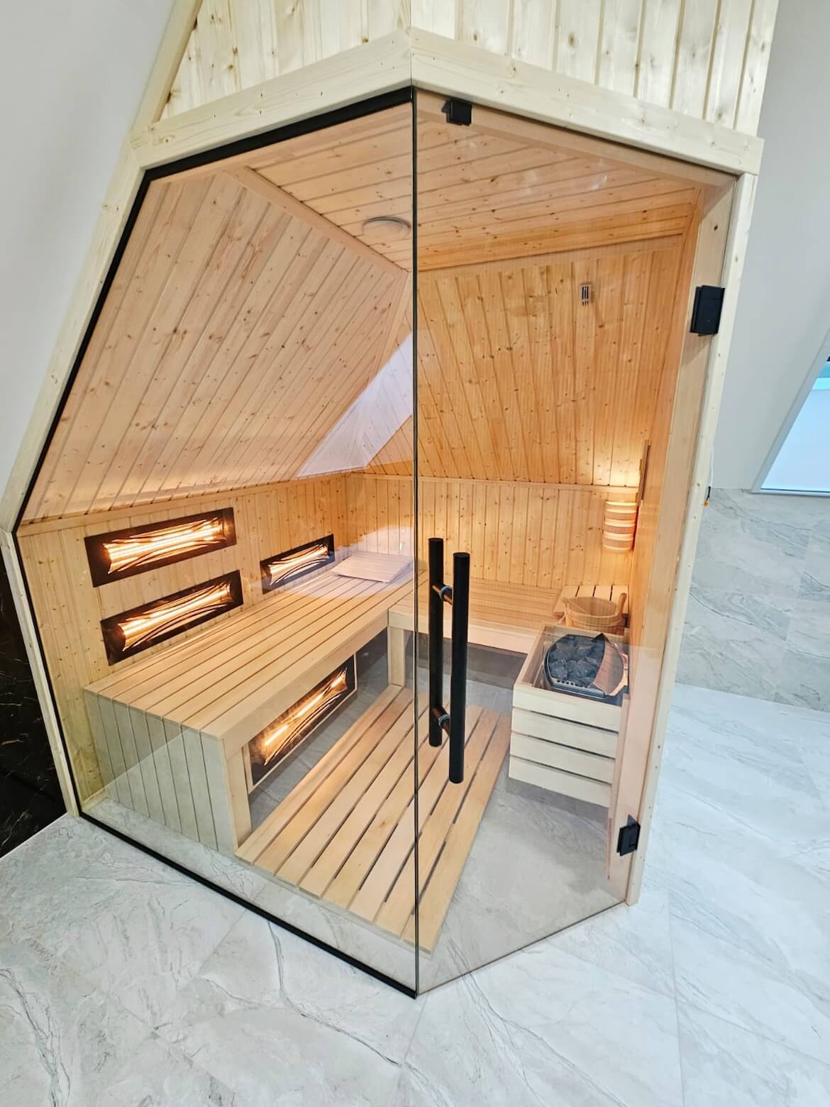 Nowoczesna sauna hybrydowa (fińska i infrared) zamontowana pod skosem dachu na poddaszu – realizacja na wymiar.